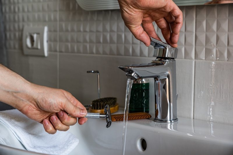 Razor being rinsed under water.